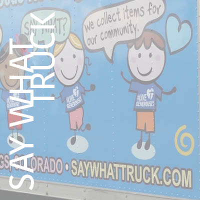 The Say what Truck wrapped in bright blue with illustrated children on the side